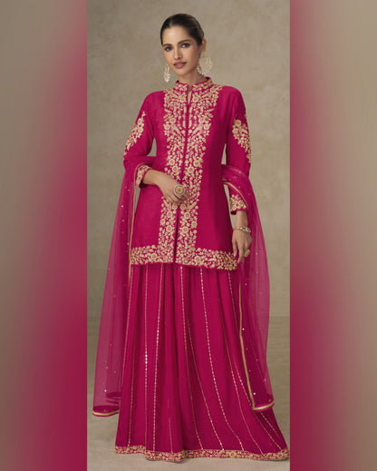 Woman wearing a pink traditional outfit with gold embroidery on a beige background