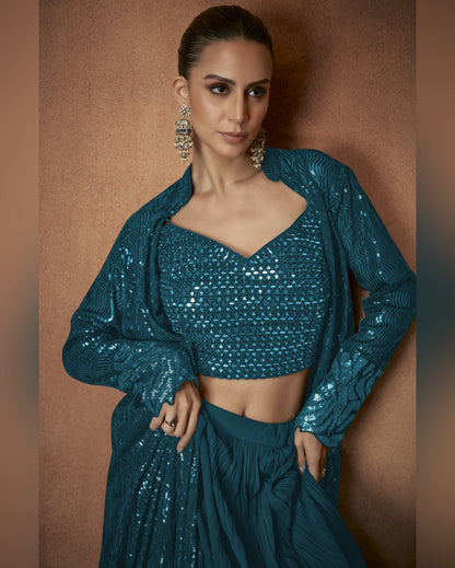 Woman wearing a teal sequin outfit against a brown background