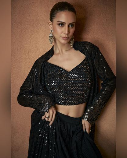 Woman wearing a black sequin outfit against a brown background