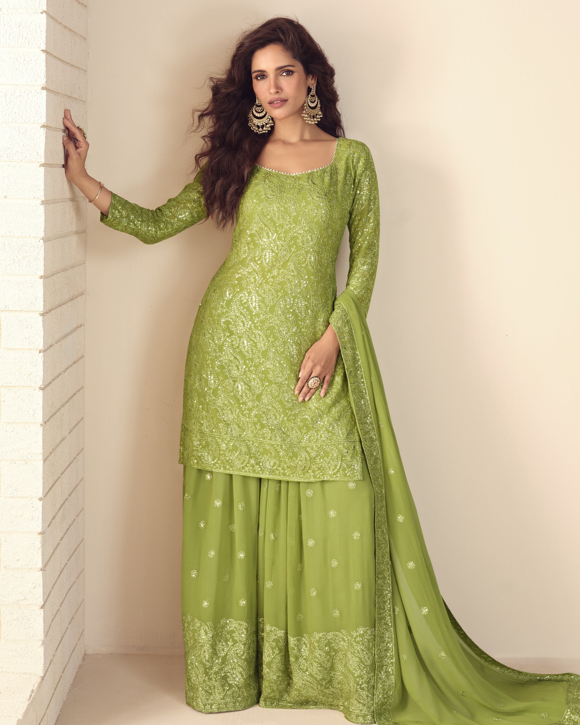 Woman wearing a green traditional outfit with a plain background