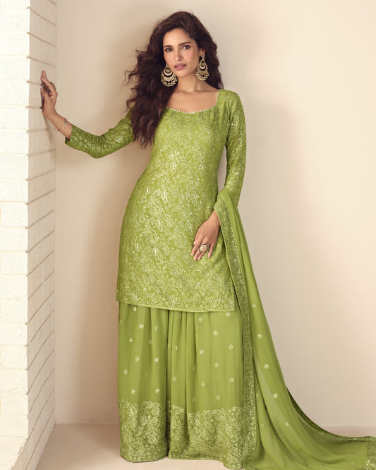 Woman wearing a green traditional outfit with a plain background