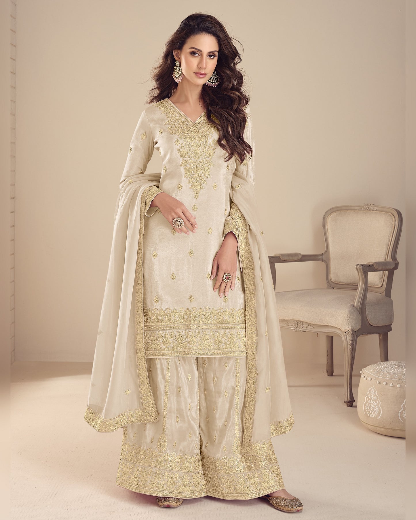 Woman in a traditional outfit with gold embroidery in a minimalistic setting