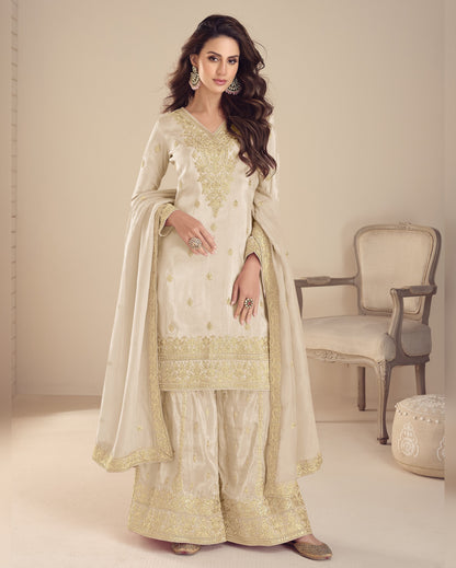 Woman in a traditional outfit with gold embroidery in a minimalistic setting