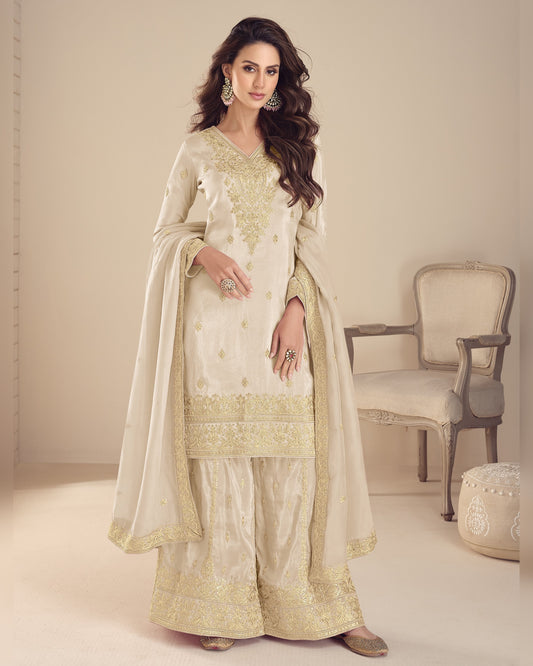 Woman in a traditional outfit with gold embroidery in a minimalistic setting