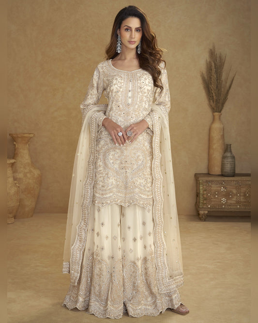 Woman wearing a cream embroidered traditional outfit with a beige background