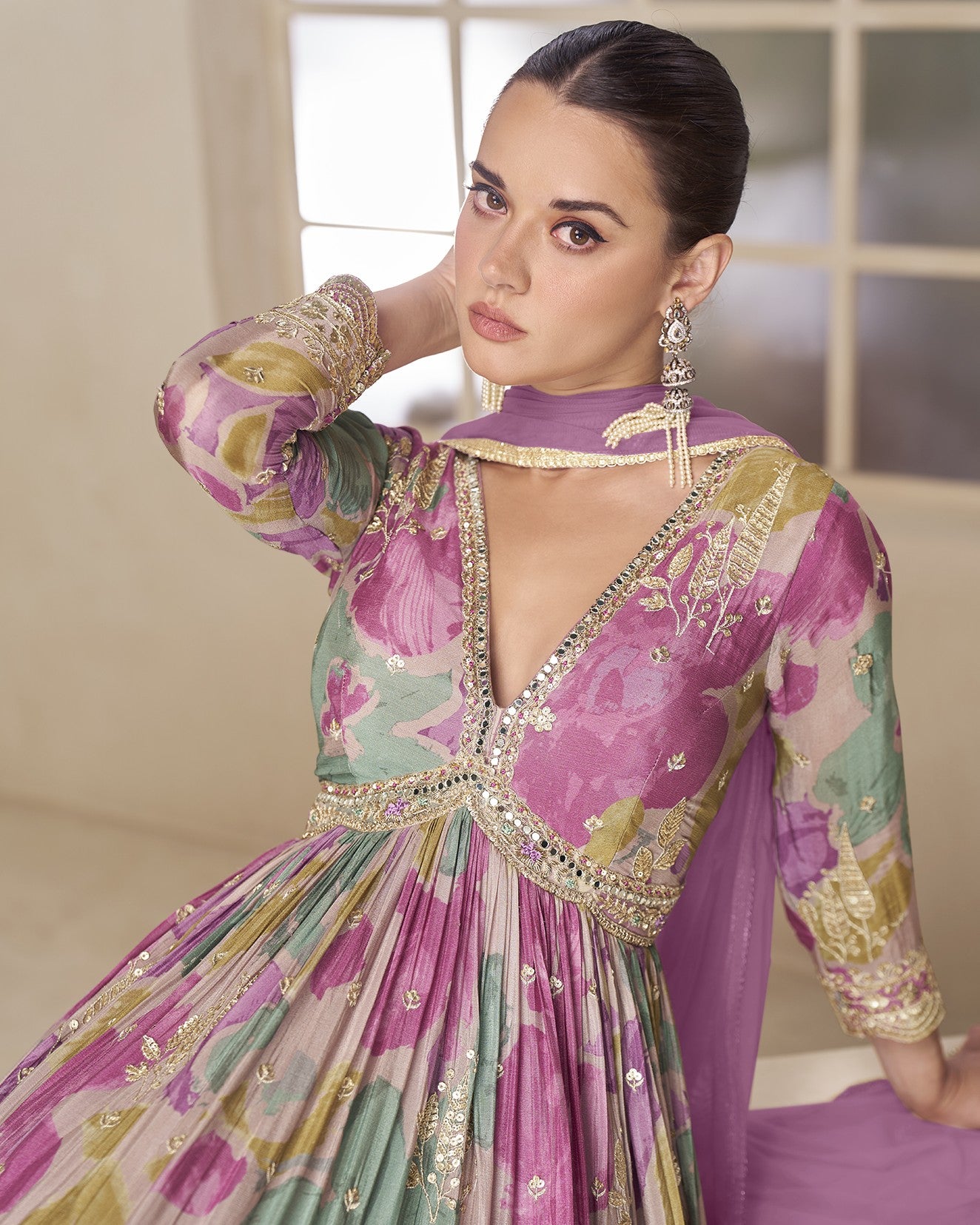 Woman wearing a colorful traditional outfit with floral patterns and intricate designs.