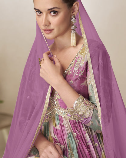 Woman wearing a traditional outfit with a purple dupatta and jewelry.