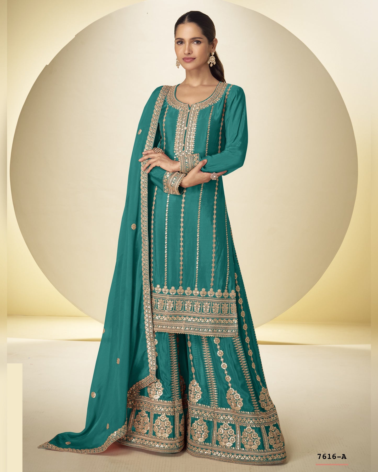 Teal traditional outfit with intricate patterns on a neutral background