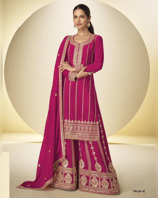 Woman wearing a pink traditional outfit with intricate designs on a neutral background