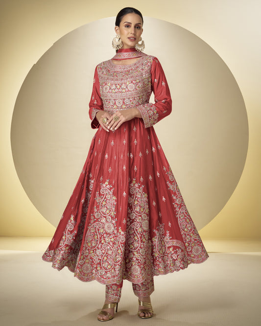 Woman wearing a red and white embroidered traditional outfit against a neutral background
