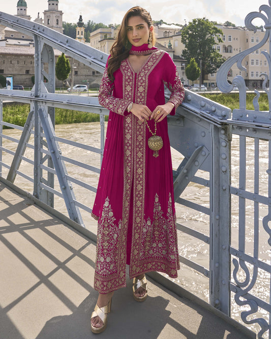 Woman in a pink traditional outfit standing on a bridge with a scenic background