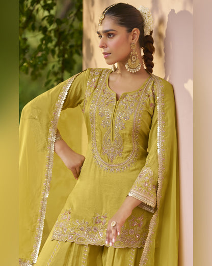 Woman wearing a green embroidered traditional outfit with a blurred natural background