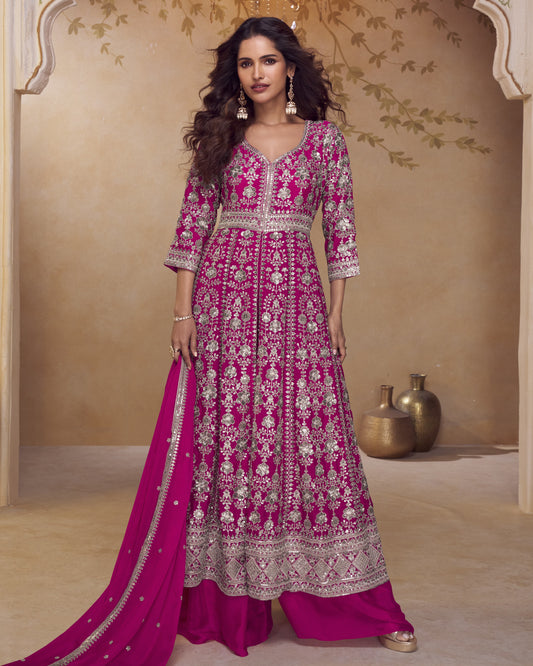 Woman wearing a pink embroidered traditional outfit with a beige background