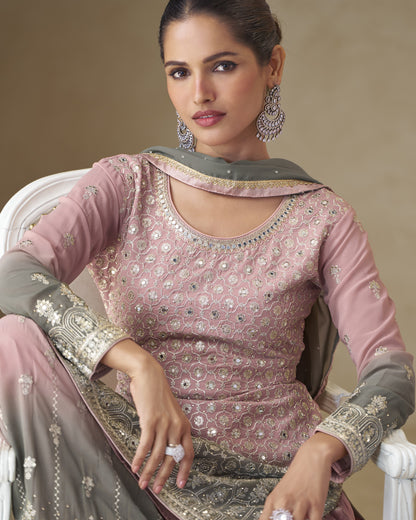 Woman wearing a pink and gray traditional outfit with intricate designs.