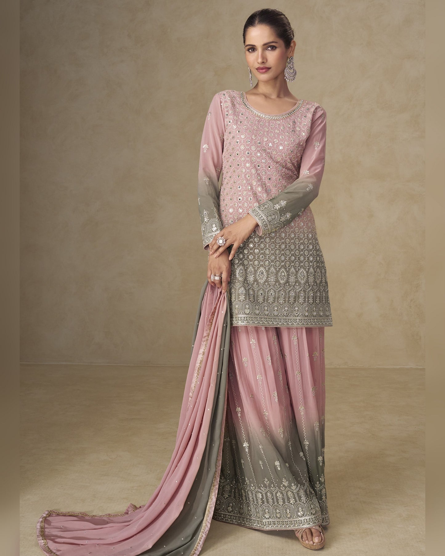 Woman wearing a pink and gray traditional outfit with a plain background