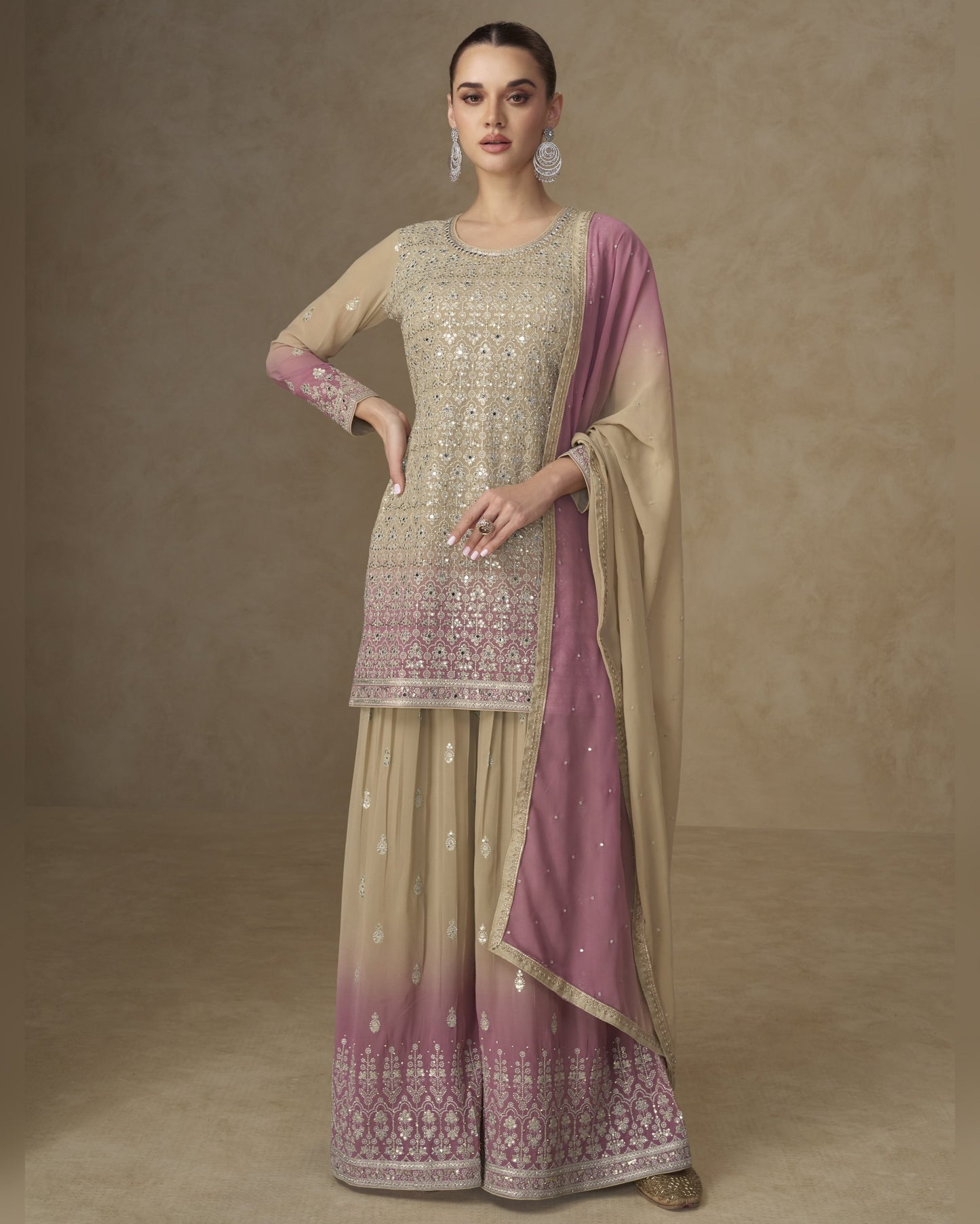 Woman wearing a traditional outfit with a beige and pink dupatta on a brown background