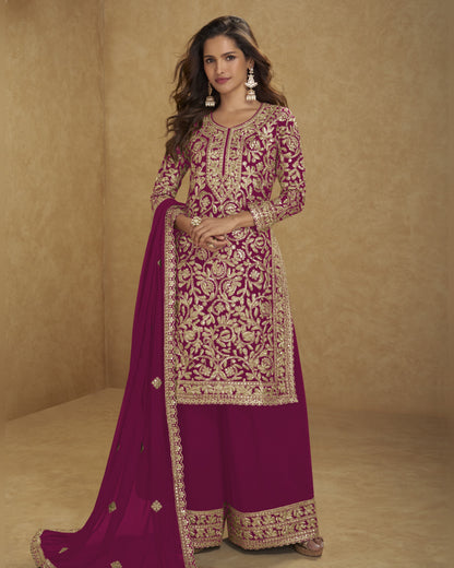Woman wearing a traditional embroidered outfit with a pink dupatta on a beige background