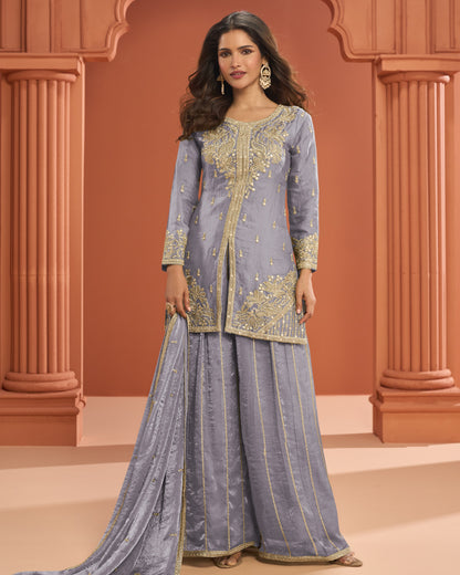 Woman wearing a traditional outfit with intricate designs in a decorative setting