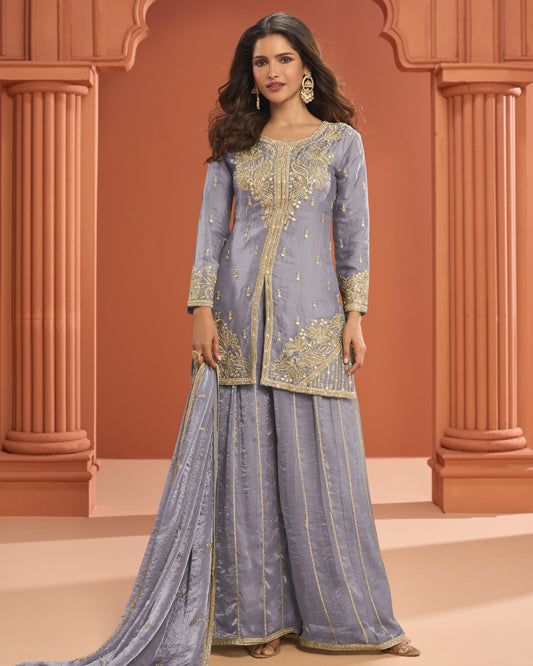 Woman wearing a traditional outfit with intricate designs in a decorative setting