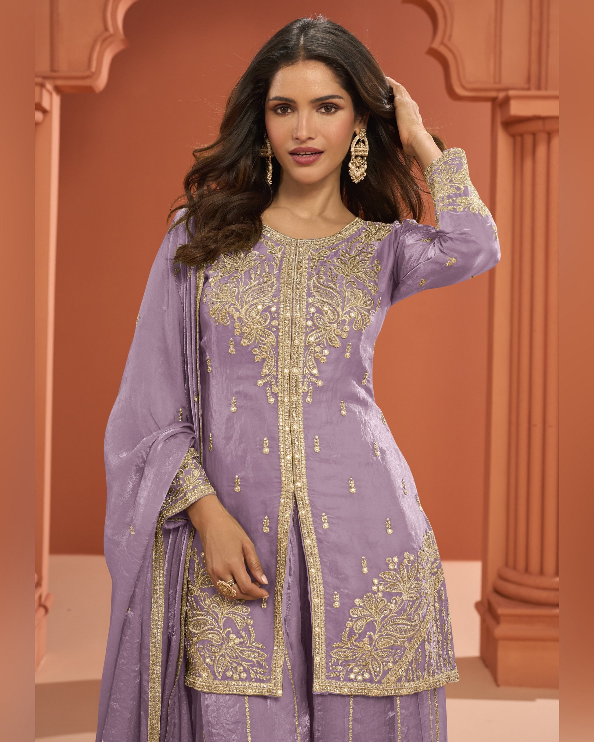 Woman wearing a purple embroidered traditional outfit with a brown background
