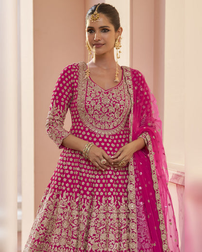 Woman wearing a pink and gold embroidered traditional outfit with a dupatta.