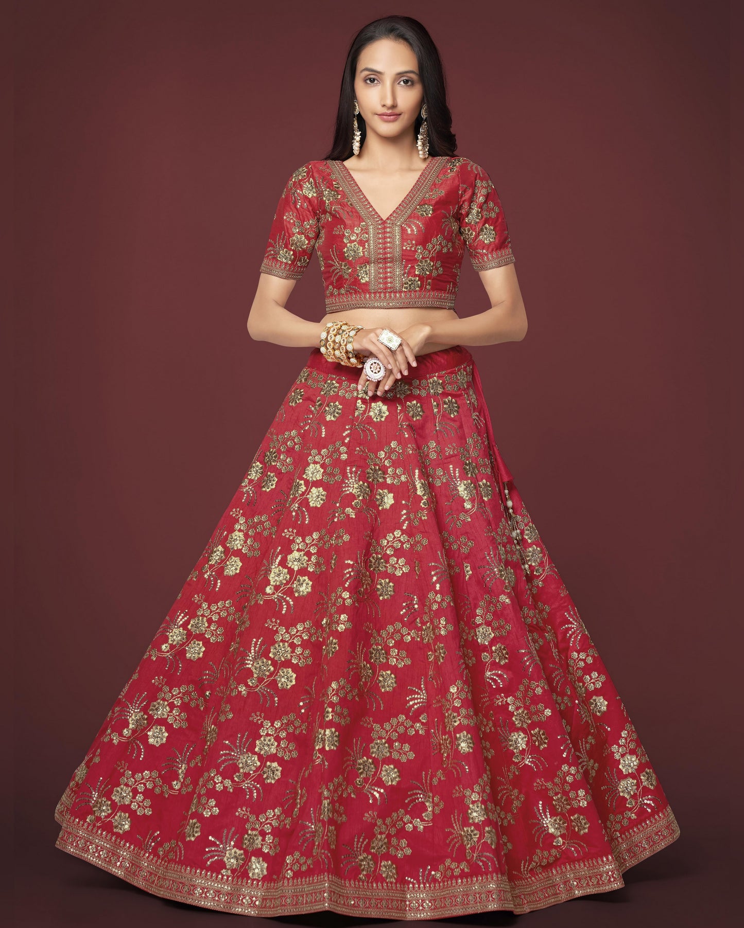 Woman wearing a red embroidered traditional outfit on a dark background