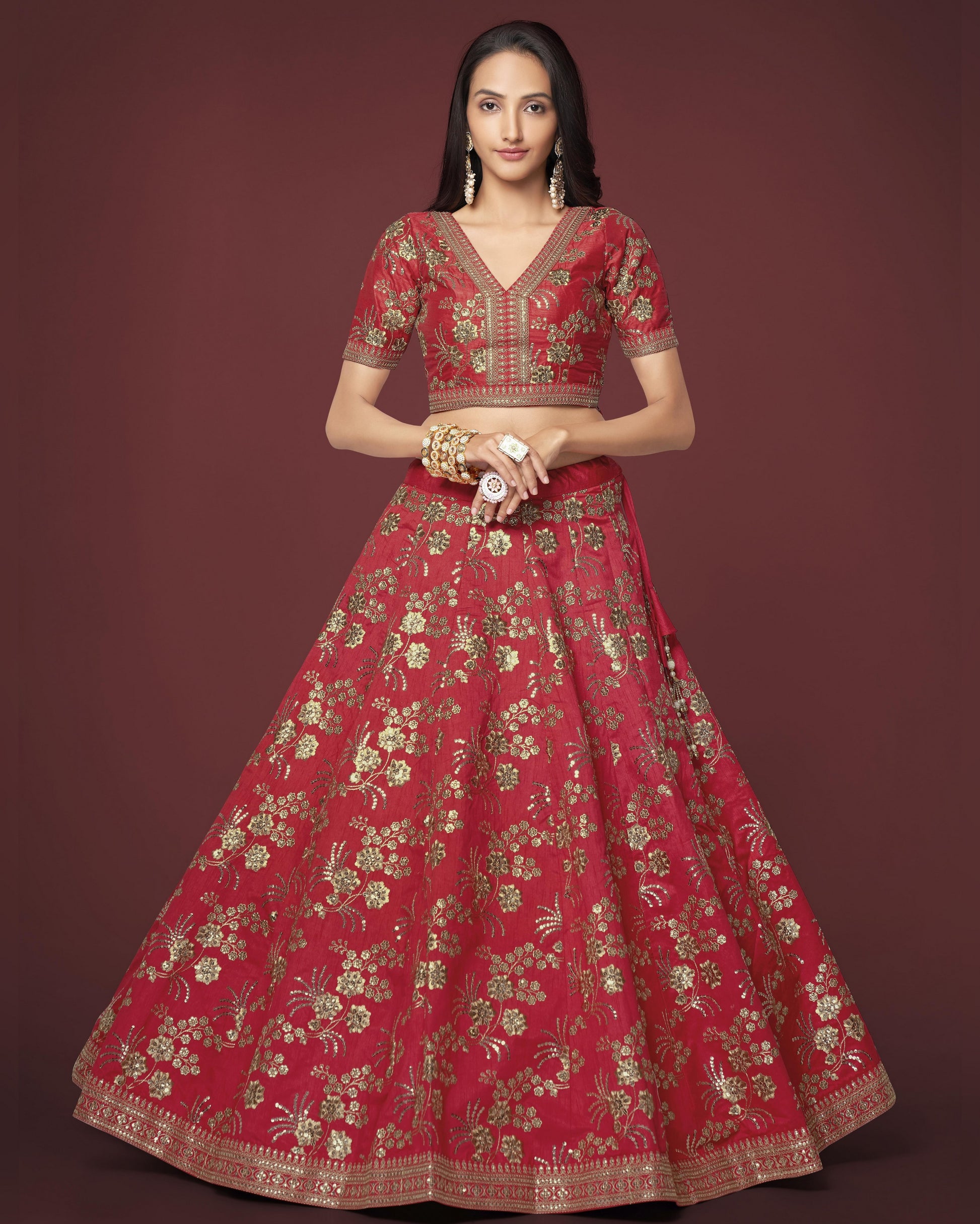 Woman wearing a red embroidered traditional outfit on a dark background