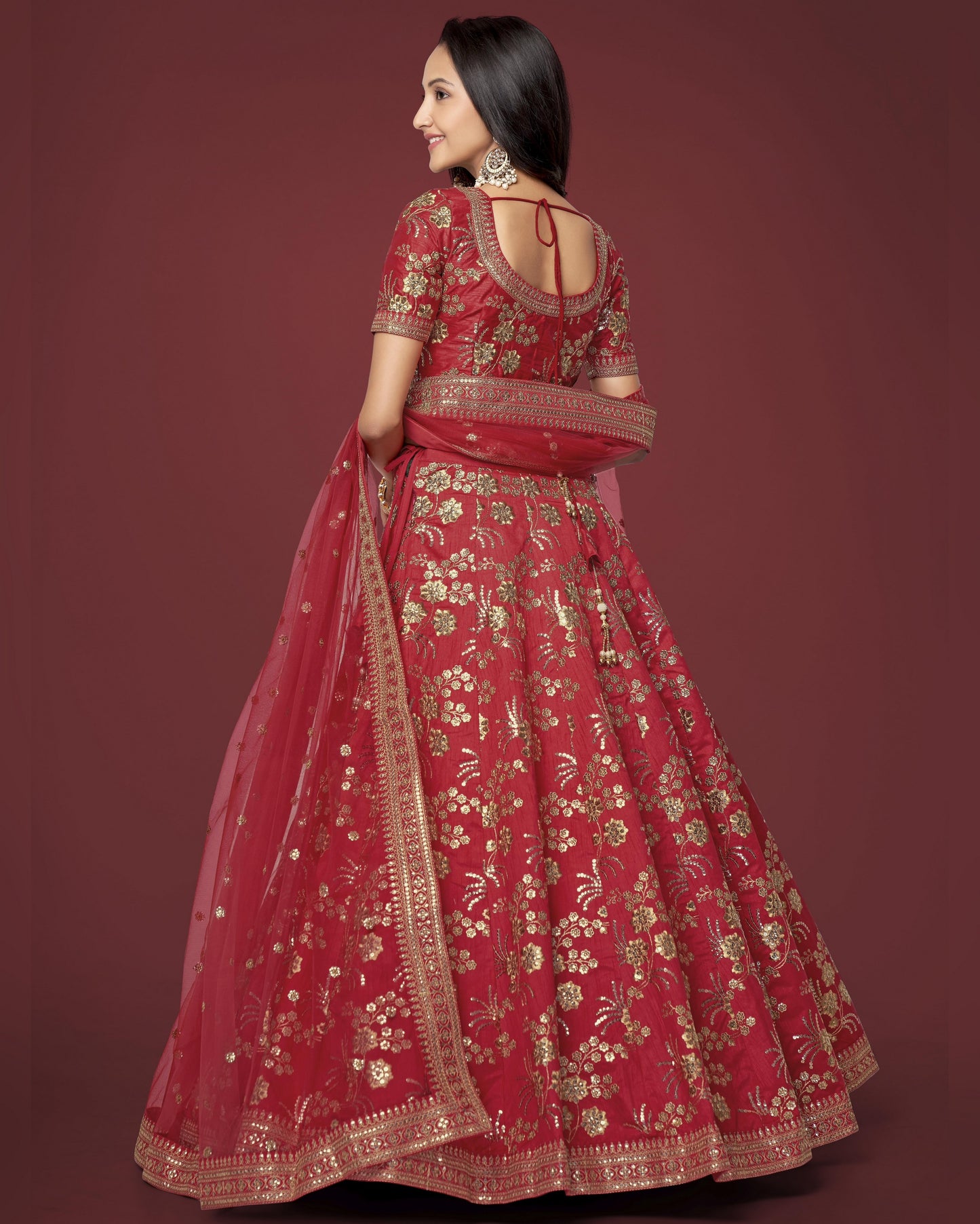 Woman wearing a red embroidered traditional outfit on a dark red background