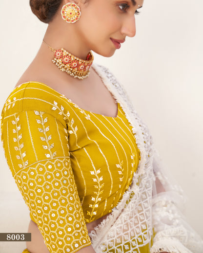 Woman wearing a yellow and white traditional outfit with jewelry on a beige background