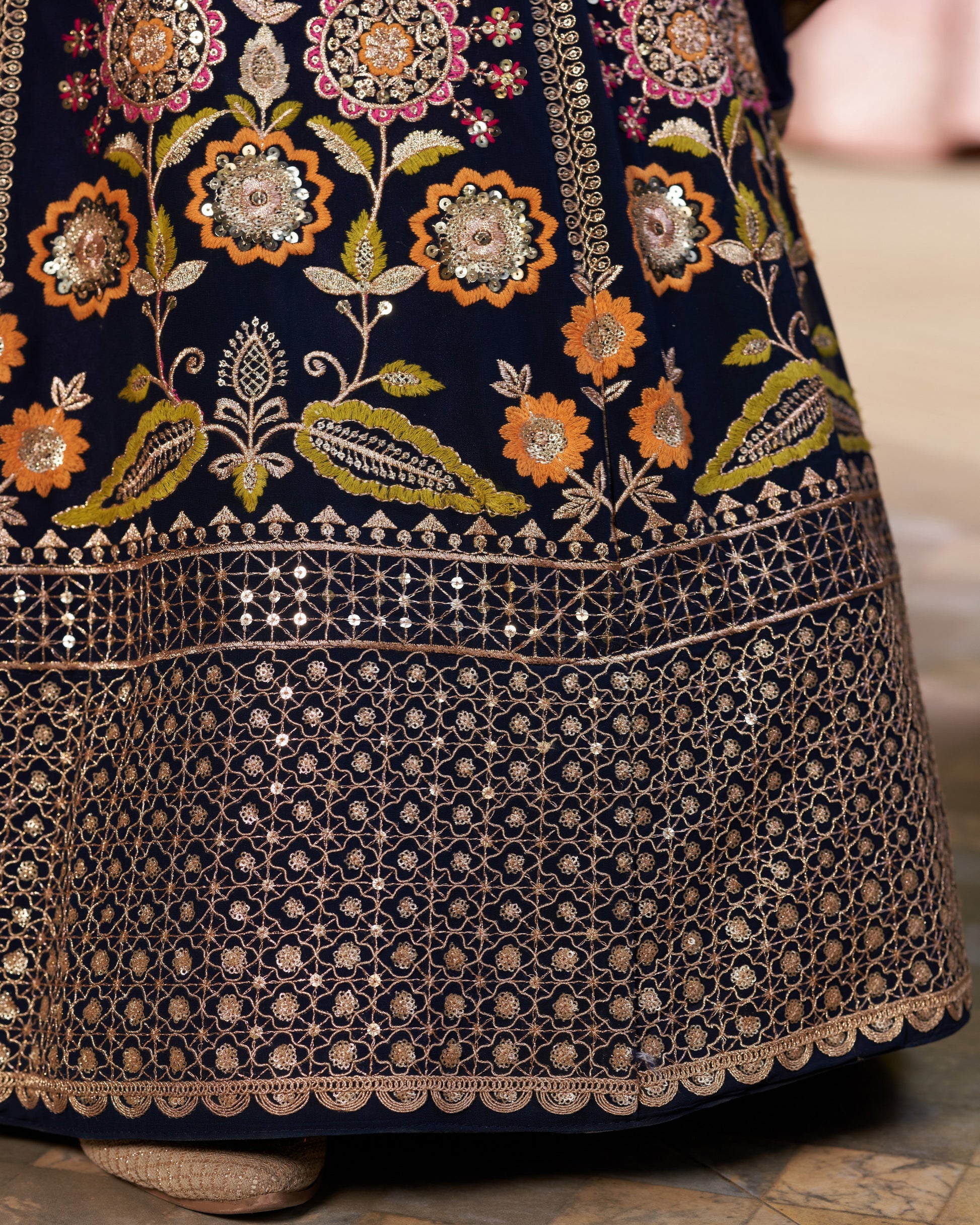 Close-up of a dark blue embroidered garment with floral patterns.