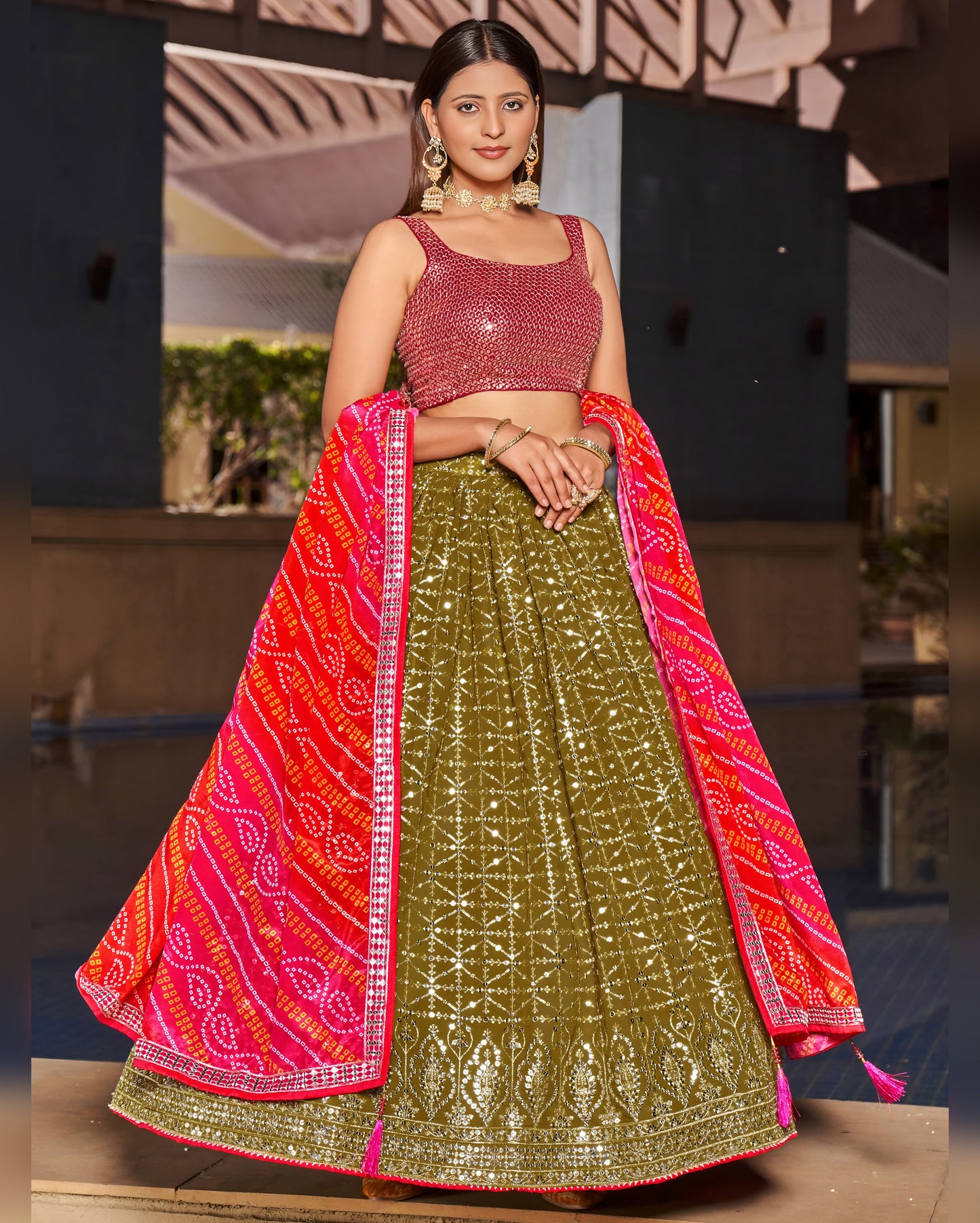Woman wearing a traditional green and pink lehenga with a blurred background