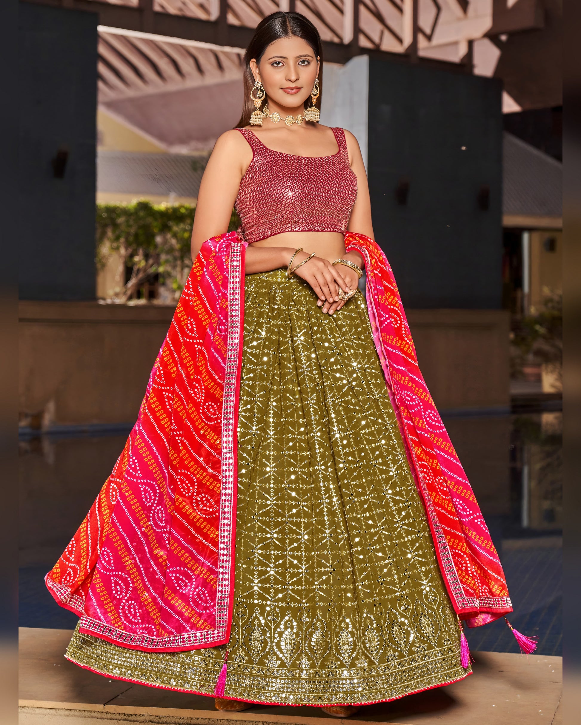 Woman wearing a traditional green and pink lehenga with a blurred background
