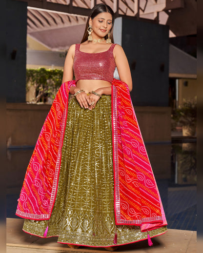 Woman wearing a traditional outfit with a pink and red dupatta and green skirt.