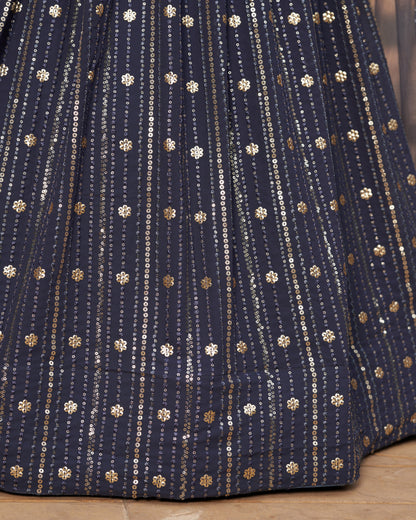 Close-up of a navy blue fabric with gold and white patterns on a wooden surface.