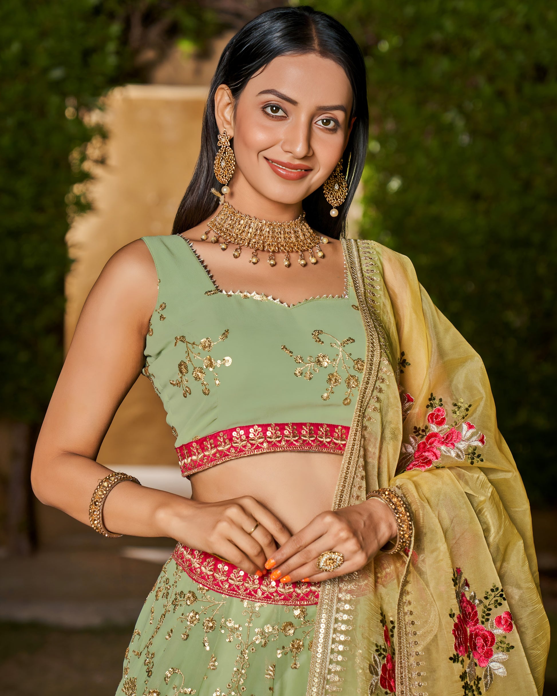 Woman in traditional green and gold outfit with floral details