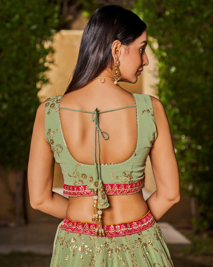 Woman wearing a green and red traditional outfit with a blurred background