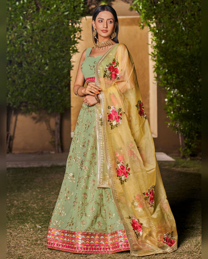 Woman wearing a traditional green and beige embroidered saree with a floral design.