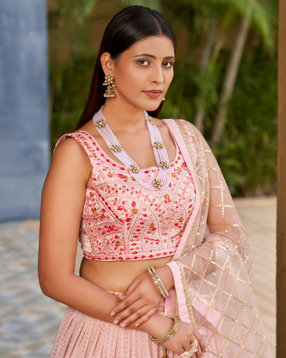 Woman wearing a pink traditional outfit with floral patterns in an outdoor setting