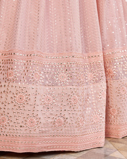 Close-up of a pink embroidered fabric with intricate patterns