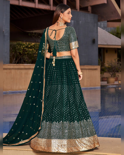 Woman wearing a dark green traditional outfit with gold details by a pool.