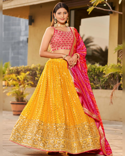 Woman wearing a yellow and pink traditional outfit with a red dupatta outdoors.