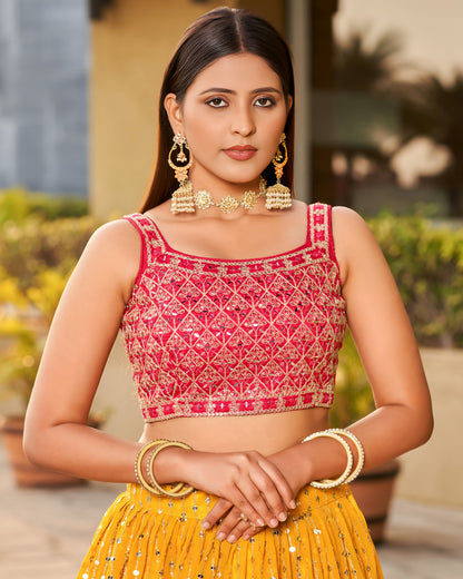 Woman wearing a pink and yellow traditional outfit with jewelry outdoors.
