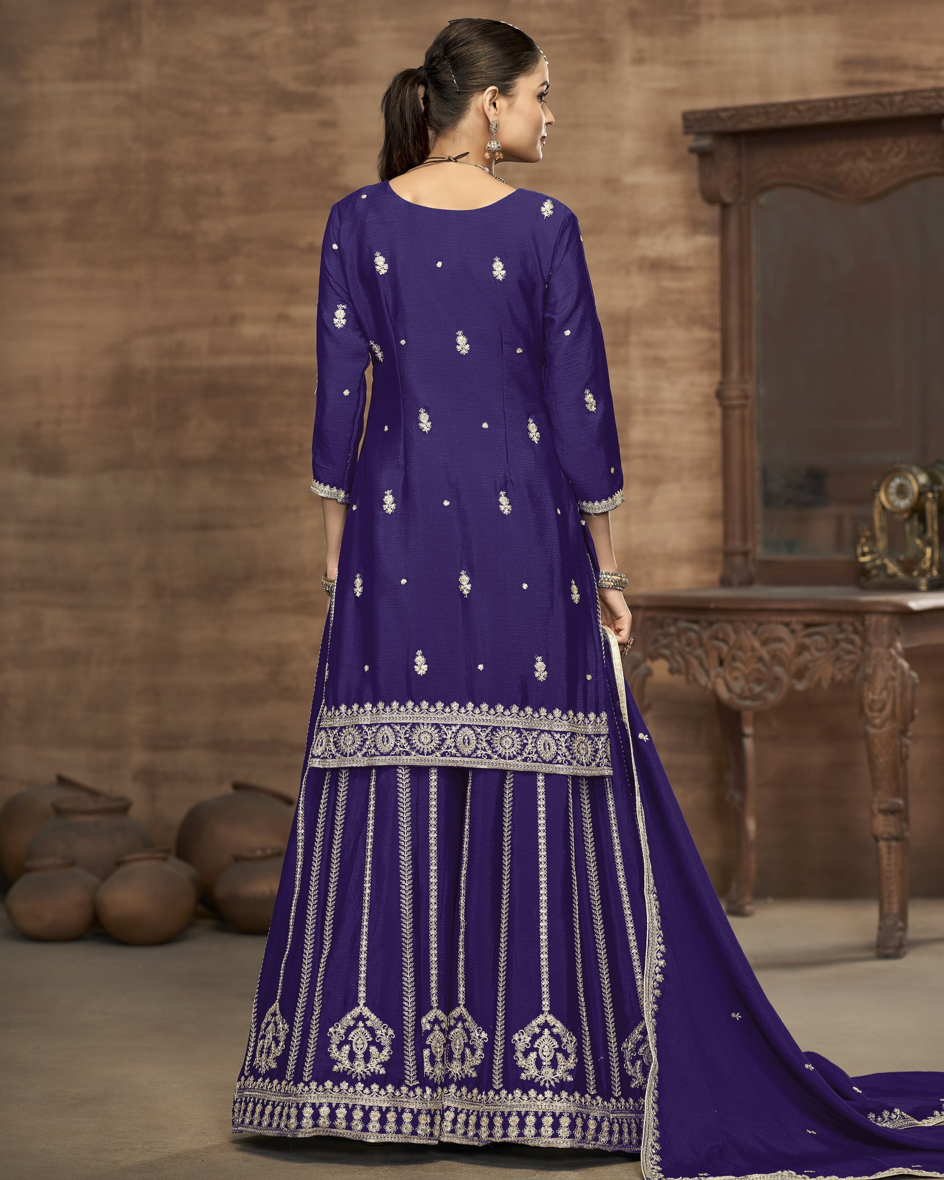 Woman wearing a purple embroidered dress in a rustic setting