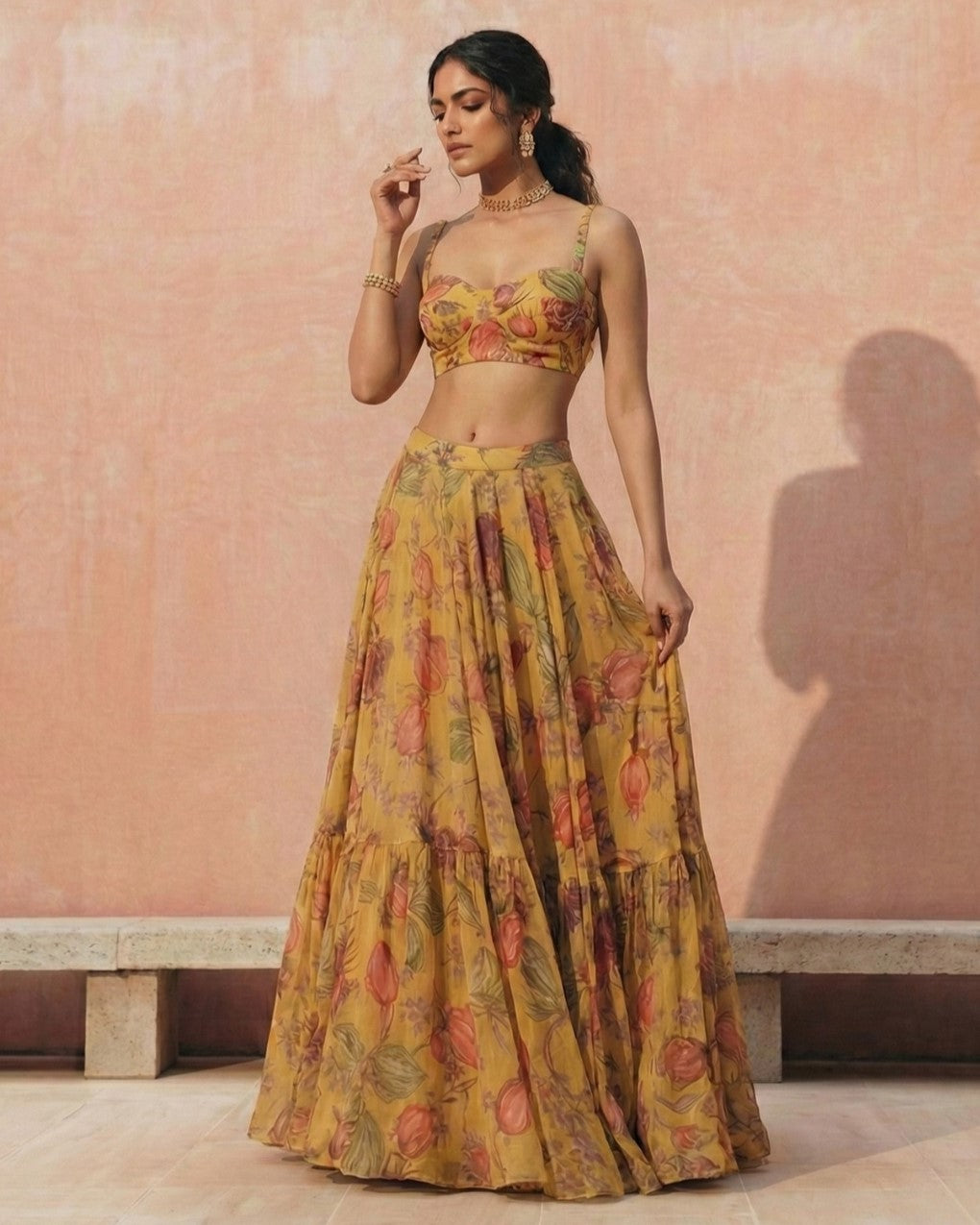 Woman wearing a floral two-piece outfit against a pink wall.