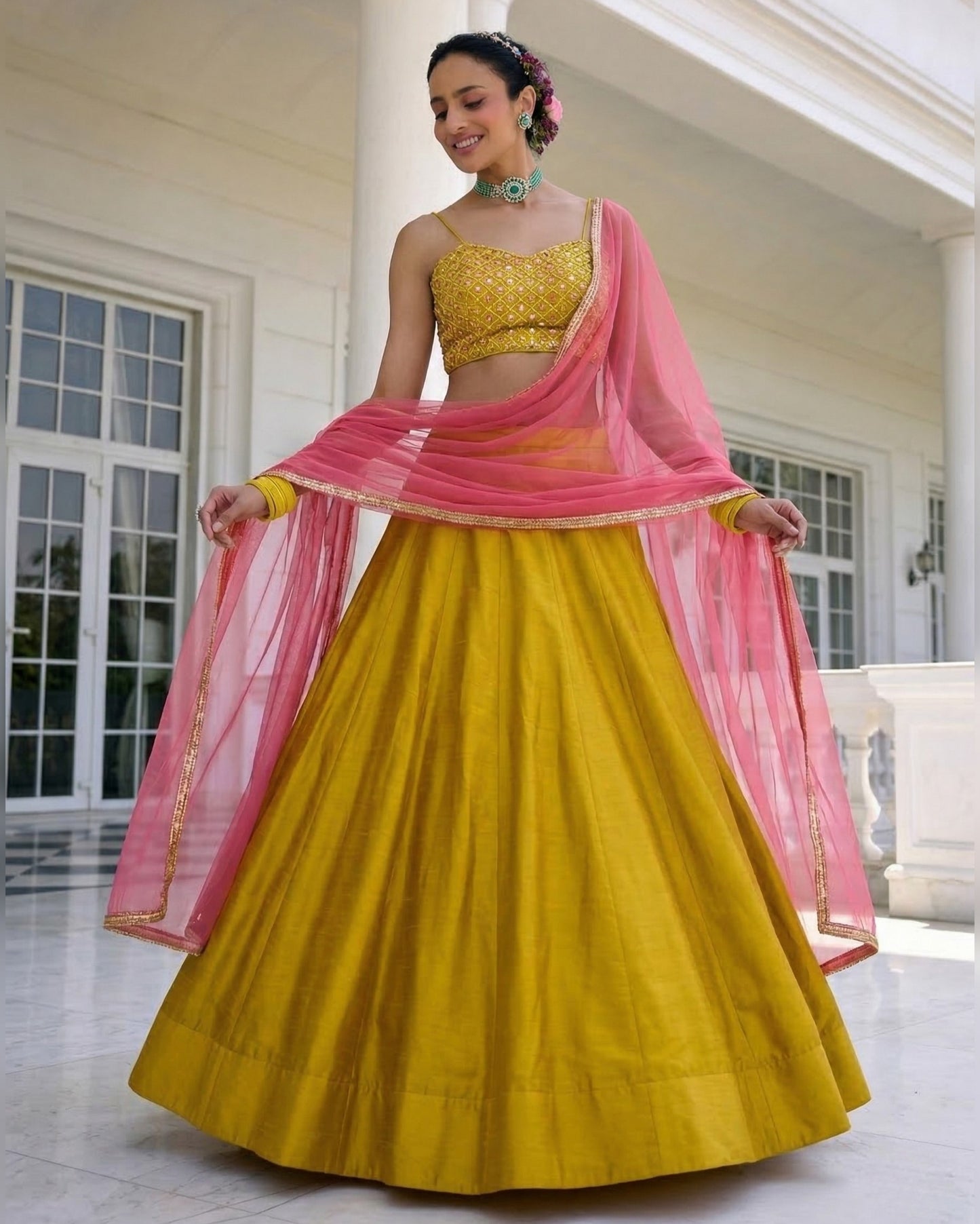 Woman wearing a yellow and pink traditional outfit in an indoor setting
