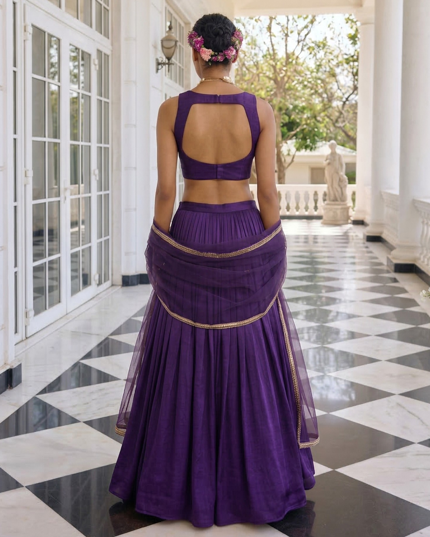 Person wearing a purple traditional outfit in a elegant indoor setting