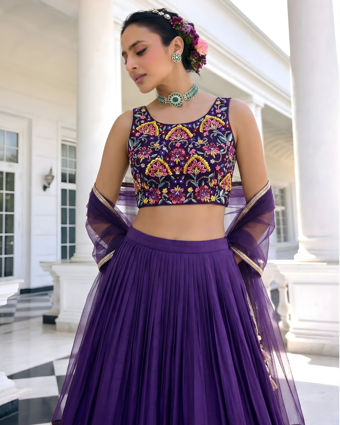 Woman in a purple traditional outfit with floral patterns in an elegant setting