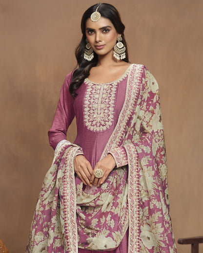 Woman wearing a traditional pink and white embroidered outfit with a brown background