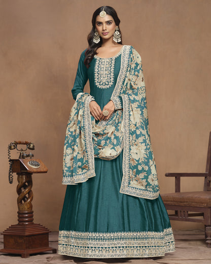 Woman wearing a teal traditional outfit with a floral shawl in a vintage setting.