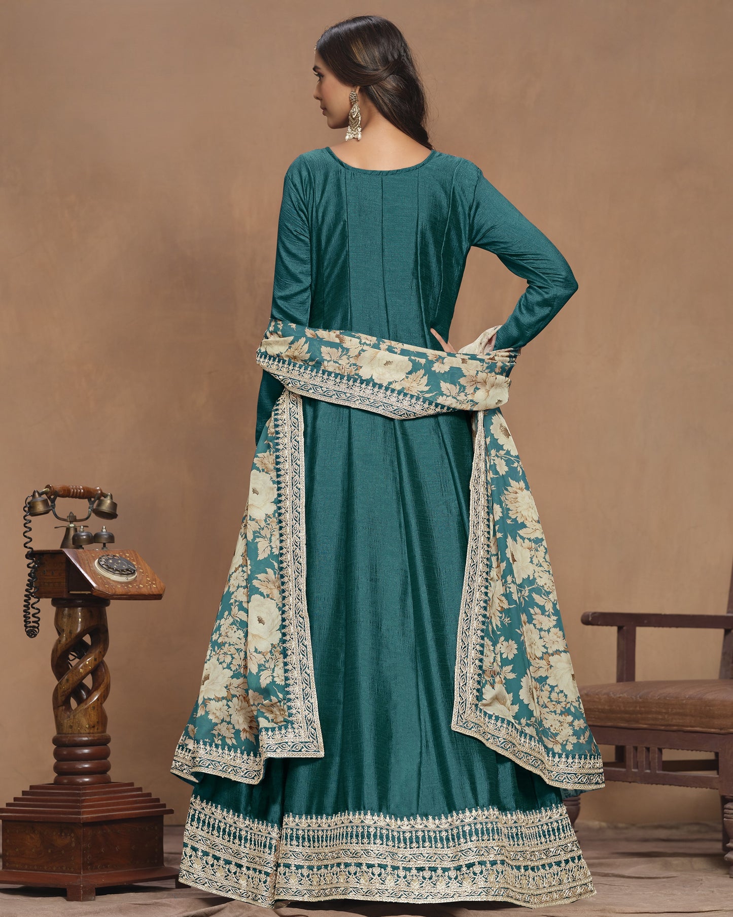 Teal traditional outfit with floral patterns on a brown background